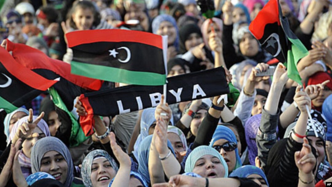 Libyans wave their new national flag as they celebrate following the official declaration of liberation of the entire country, October 23, 2011.