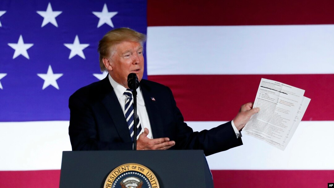 El presidente Donald Trump muestra una lista de los logros de su administración, en el Carmel Country Club en Charlotte, Carolina del Norte.