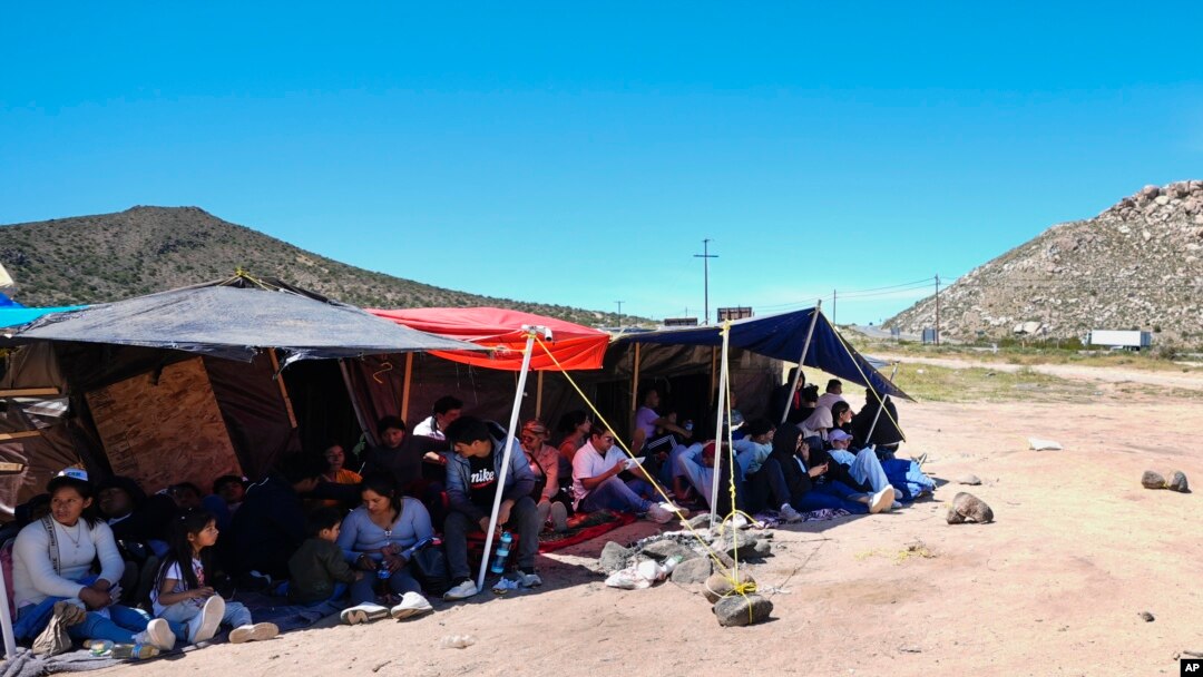 ARCHIVO: Un grupo de personas esperan a ser procesadas después de cruzar la frontera entre México y Estados Unidos para solicitar asilo, el miércoles 17 de abril de 2024, cerca de Jacumba, California. 