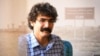 Iranian Gonabadi Dervish journalist Mohammad Sharifi Moghadam is seen in this undated photo set against the backdrop of the Greater Tehran Penitentiary.