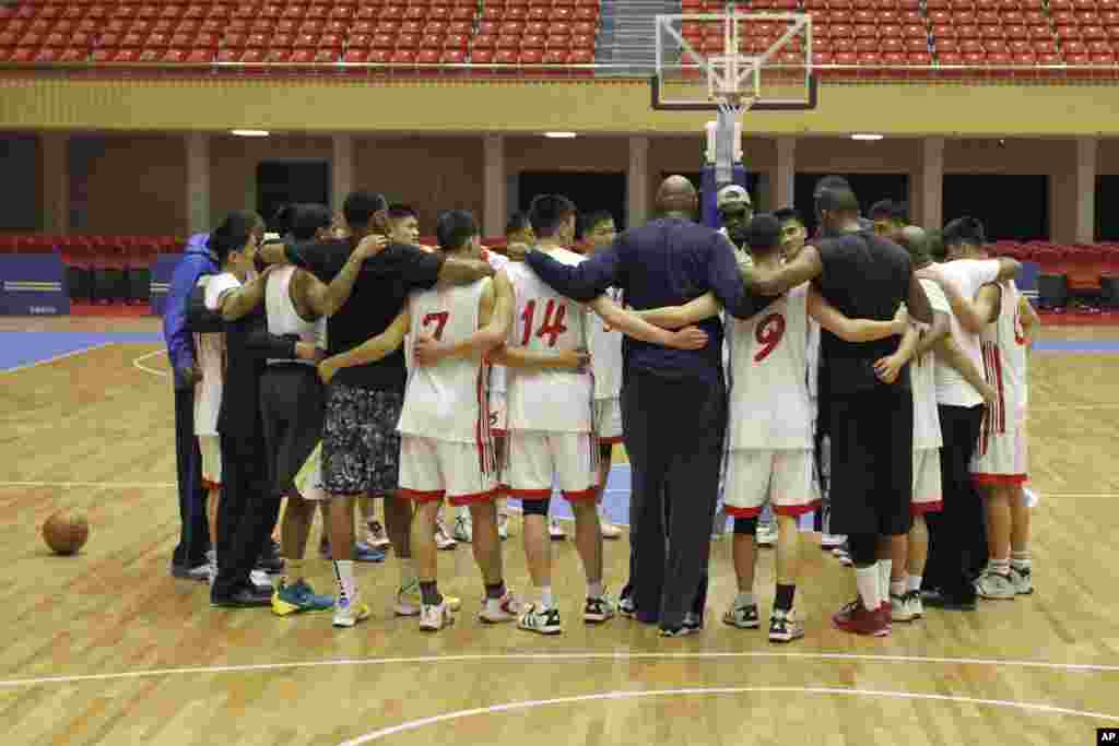 Dennis Rodman huddles with North Korean basketball players and fellow former NBA stars at a practice session in Pyongyang, Jan. 7, 2014.