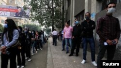 Women and men wait in separate lines to cast their votes, outside a school used as a polling station during the second round of Egypt's parliamentary election in Cairo, Egypt, Nov. 7, 2020.