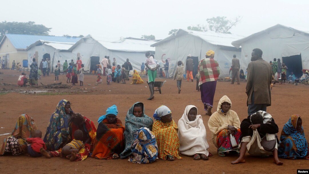 Congolese families sit at the Kyangwali refugee settlement camp, Uganda, March 19, 2018. A California company is testing an app in Uganda that lets refugees earn money for AI training.
