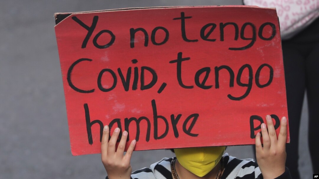 Una mujer sostiene un cartel con la frase "Yo no tengo Covid, tengo hambre" durante una marcha en Quito, Ecuador, el 16 de julio de 2020.
