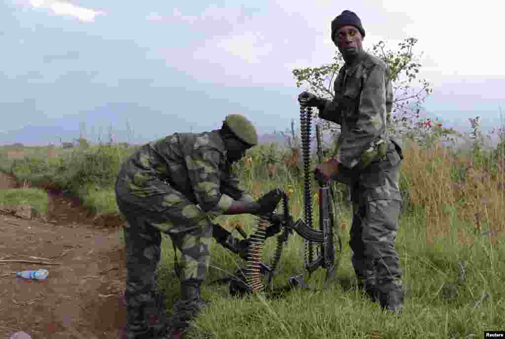 Soldiers from the Democratic Republic of Congo check their weapons near the town of Kibumba at its border with Rwanda after fighting broke out, June 11, 2014.