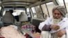 Afghan men investigate the site of a shooting incident in Kandahar province, March 11, 2012