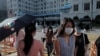 People wearing masks to protect against the coronavirus, walk across a street in Hong Kong, Aug. 20, 2020.