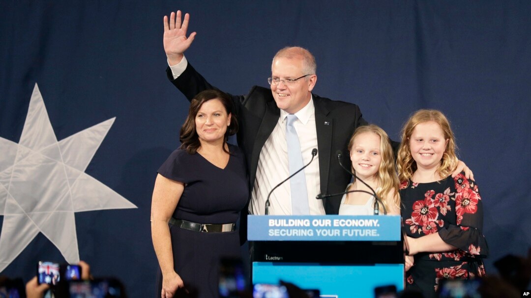 El primer ministro australiano Scott Morrison, segundo a la izquierda, llega al escenario para hablar con sus partidarios acompañado por su esposa, Jenny, a la izquierda, y sus hijas Lily y Abbey, a la derecha, después de que su oponente accediera a las elecciones.