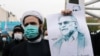 FILE - A protester holds a picture of Mohsen Fakhrizadeh, Iran's top nuclear scientist, during a demonstration against his killing in Tehran, Iran, November 28, 2020. (Majid Asgaripour/WANA via REUTERS)