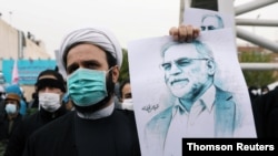 FILE - A protester holds a picture of Mohsen Fakhrizadeh, Iran's top nuclear scientist, during a demonstration against his killing in Tehran, Iran, November 28, 2020. (Majid Asgaripour/WANA via REUTERS)