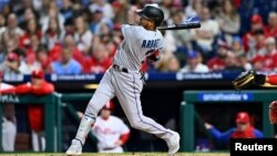 El venezolano Luis Arráez hace swing para batear un triple contra los Filis de Filadelfia, el 11 de abril de 2023.