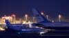A plane, left, carrying three Iranian-Americans who left Tehran under a prisoner swap, lands at Cointrin airport in Geneva, Switzerland, Jan. 17, 2016.