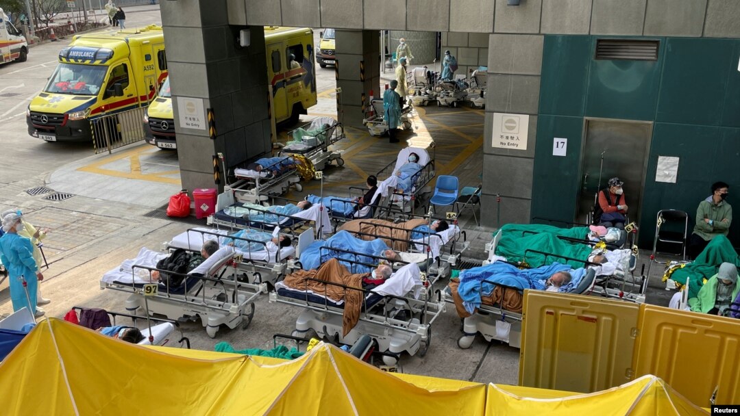 Patients wearing face masks lie in bed at a makeshift treatment area outside a hospital, following the COVID-19 outbreak in Hong Kong, Feb. 16, 2022. 
