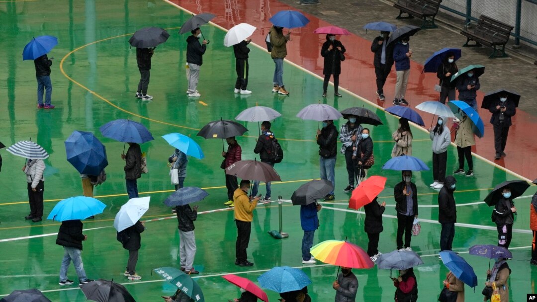 Residents line up to get tested for the coronavirus at a temporary testing center despite the rain in Hong Kong, Feb. 22, 2022.