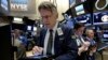 FILE - A trader works on the floor of the New York Stock Exchange, March 18, 2016. 