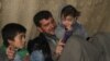 Hoger, left, a 10-year-old Yazidi boy from Sinjar, sits with his orphanage housefather Rami Qaddor and Qaddor’s daughter. Hoger has been living in an orphanage in Atmeh refugee camp, northern Syria.