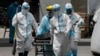 Health workers in protective suits transport a dead body at a hospital in Manila, Philippines. The capital and outlying provinces returned to another lockdown after medical groups warned that the country was waging a losing battle against the coronavirus.