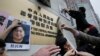 FILE - Activists paste photos of missing booksellers, one of which shows Gui Minhai at left, during a protest outside the Liaison Office of the Central People's Government in Hong Kong, Jan. 3, 2016.