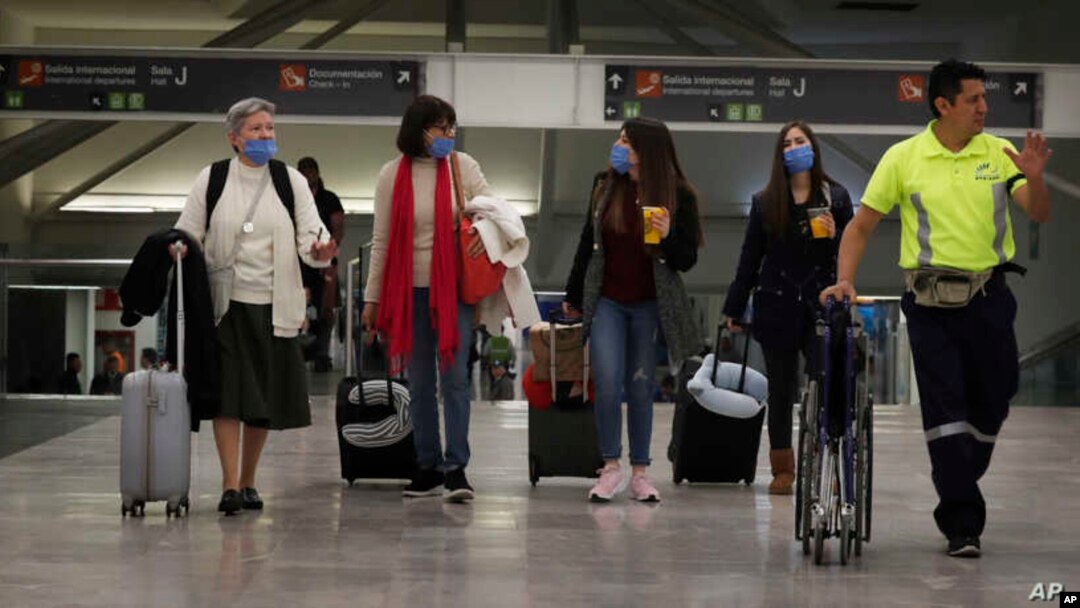 Las personas usan máscaras protectoras como precaución contra la propagación del nuevo coronavirus en el aeropuerto de la Ciudad de México, el viernes.