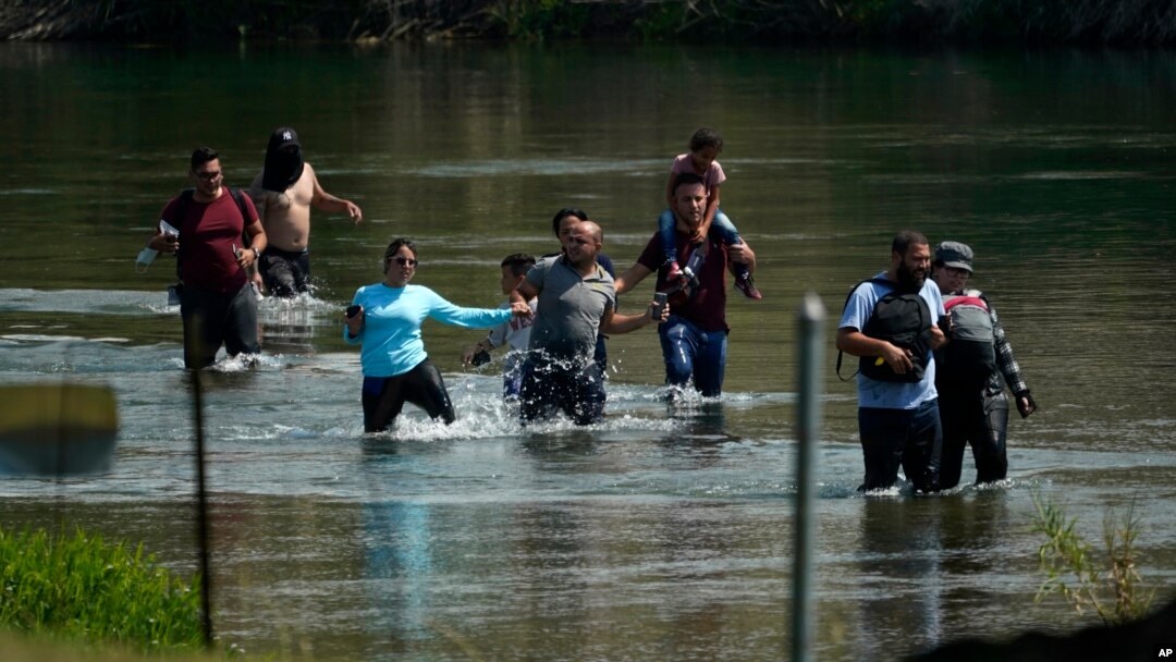 Un grupo de migrantes, principalmente de Venezuela, vadea el río Bravo al cruzar la frontera entre Estados Unidos y México el miércoles 16 de junio de 2021 en Del Rio, Texas.