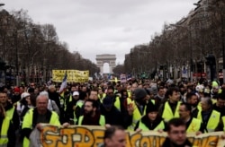 FILE - Yellow vest protesters march on Champs Elysees avenue in Paris, France, March 2, 2019.