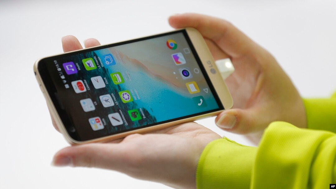 A woman shows the new LG's G5 smartphone during the LG unpacked 2016 event on the eve of this week’s Mobile World Congress wireless show, in Barcelona, Spain, Feb. 21. 2016. 