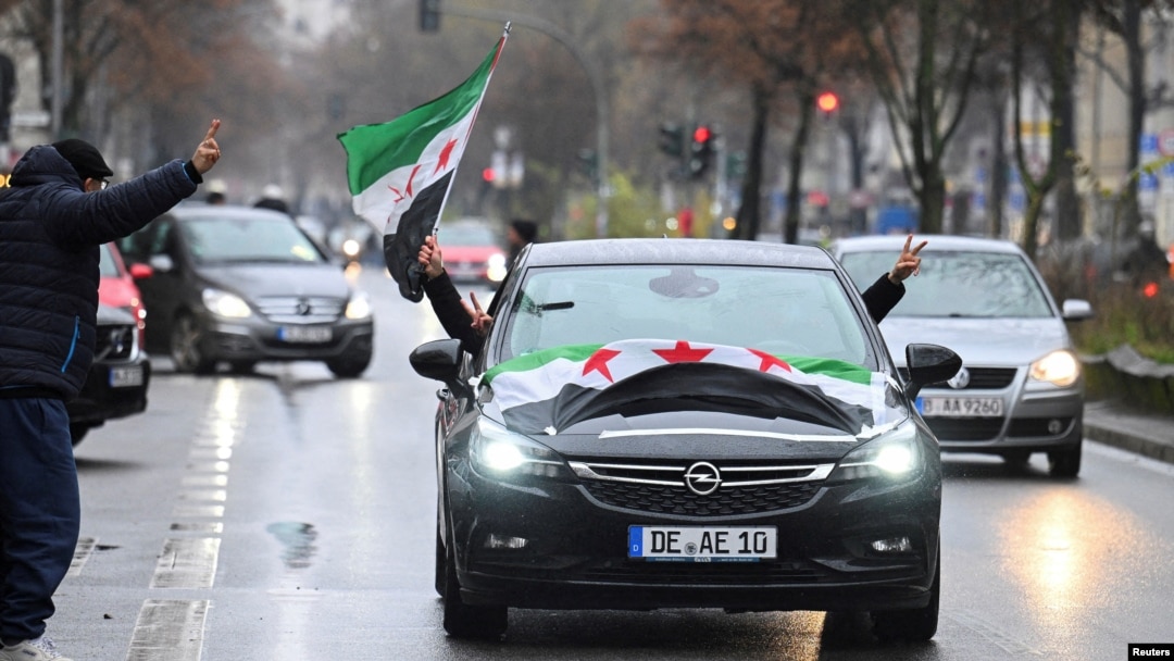 People ride in a car decorated with Syrian opposition flags, after Syrian rebels announced that they have ousted Syria's Bashar al-Assad, in Berlin, Germany, Dec. 8, 2024. 