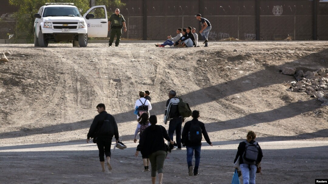 Se ve a los migrantes después de cruzar ilegalmente a Estados Unidos para entregarse y solicitar asilo en El Paso, Texas.