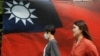 大眾從台北街頭的台灣旗幟旁走過。（2020年8月10日）