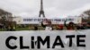 Environmentalists hold a banner that reads "Standing and Determined for the Climate" at a climate conference protest demonstration near the Eiffel Tower in Paris, France, Dec. 12, 2015. 
