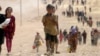 FILE - Children from the minority Yazidi sect, fleeing violence from Islamic State militants in Sinjar, Iraq, make their way toward the town of Elierbeh of Al-Hasakah Governorate, near the Syrian border, Aug. 10, 2014. 