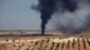 FILE - Smoke rises due to what forces loyal to Syria's President Bashar al-Assad claimed to be shelling by them, beside the village of Hilan.