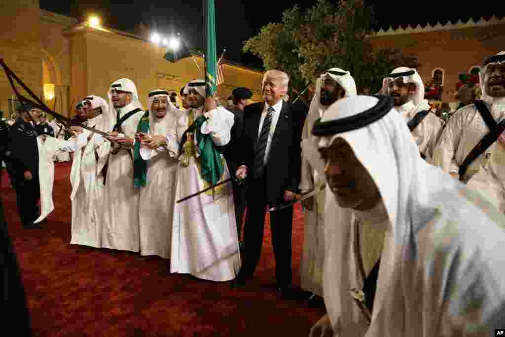 President Donald Trump holds a sword and sways with traditional dancers during a welcome ceremony at Murabba Palace in Riyadh, Saudi Arabia, May 20, 2017.