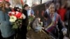People bring flowers to the Venezuelan embassy to pay tribute to the late Venezuelan President Hugo Chavez, in Minsk, March 6, 2013.