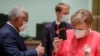 António Costa (e), primeiro-ministro de Portugal, oferece um presente a chanceler alemã, Angela Merkel( d), num dos intervalos da cimeira de Bruxelas. 
