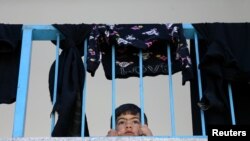 Un niño palestino que huyó de su hogar en la Franja de Gaza observa desde el interior de una escuela de Naciones Unidas donde está refugiado en la ciudad de Gaza el 19 de mayo de 2021.