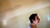 FILE - A patient is seen walking a hallway at a mental health institution in the Balkans.