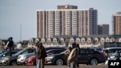 Curiosos tratan de ver el momento en que el antiguo Trump Plaza Hotel and Casino es demolido con una implosión controlada, más de 30 años después de su construcción. El hotel cerró en 2014.