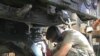 A National Guard soldier in Robbins, Illinois repairs a military Humvee