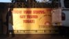 FILE - The shadow of a pedestrian is cast over a banner for a HIV testing center in Gaborone, Botswana.