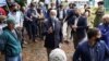 Democratic presidential candidate former Vice President Joe Biden holds his mask as he speaks to members of the media outside a voter service center, Oct. 26, 2020, in Chester, Pa.