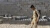 FILE - An Iraqi soldier scans the ground for weapons during a raid in Basra, Iraq, Sept. 8, 2020. 