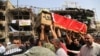 Mourners carry the Iraqi flag-draped coffin of, Akram Hadi, 24, in a Sunday massive truck bomb attack in the Karada neighborhood of Baghdad, Iraq, July 5, 2016. 