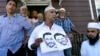 Members of the Al-Furqan Jame Mosque in Queens, New York, display a police sketch of a man suspected of shooting two clerics Saturday. Oscar Morel, 35, has been charged in the crime.