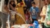 FILE - Residents fill up buckets with water from cisterns provided by humanitarian organisations during water shortages in Syria's northeastern city of Hasakah, Aug. 22, 2020.
