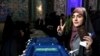 A woman flashes a victory sign with her inked finger while voting in parliamentary elections, at a polling station in Tehran, Iran, Feb. 21, 2020.