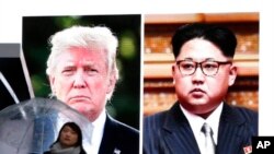 一名女子走過東京街頭正在播放川普與金正恩的有關電視新聞的巨型屏幕（資料圖片）
