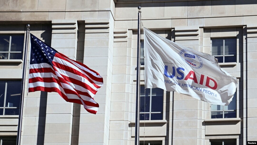 FILE PHOTO: An American flag and USAID flag fly outside the USAID building in Washington