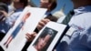 FILE - Fathers who lost their children to spousal abduction to Japan hold photos of their children during a news conference on Capitol Hill in Washington, May 5, 2010 In 2013, Japan’s parliament approved joining the 1980 Hague Convention on international child abduction, a global child custody treaty, amid foreign concerns that Japanese mothers can take children away from foreign fathers without recourse. 