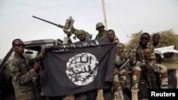 Sojojin Najeriya suke nuna tutar Boko Haram da suka kwace.